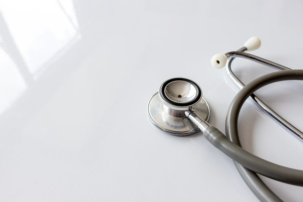 annual checkup concept. stethoscope on white table with soft-focus and over light in the background