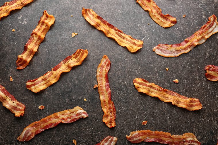 Strips of fried bacon on gray background