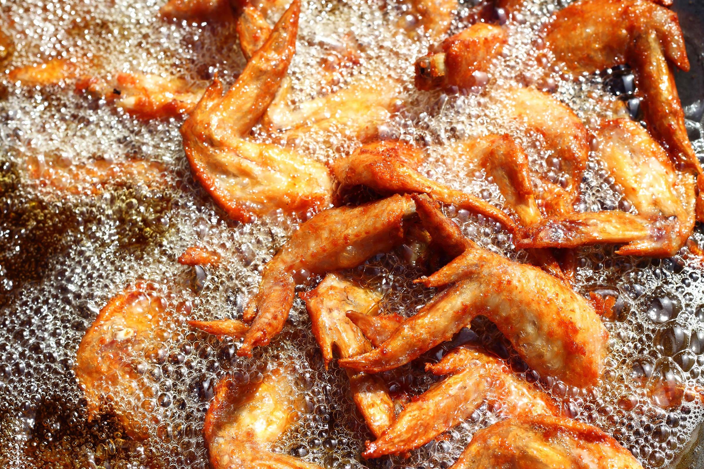 fried chicken wings sizzling in hot oil