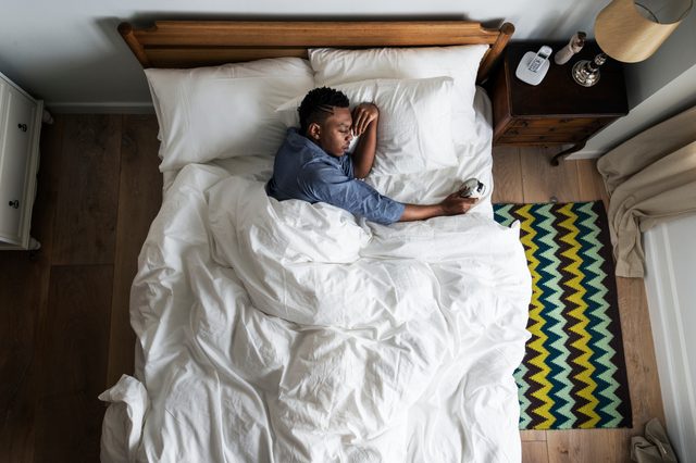 Man waking up in the morning by an alarm clock