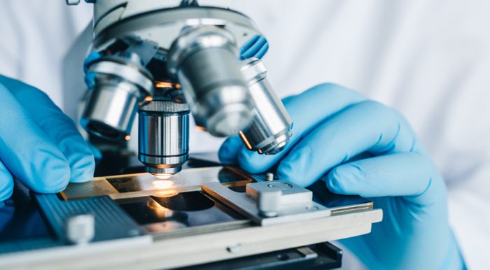 Close-up shot of microscope with metal lens at laboratory.