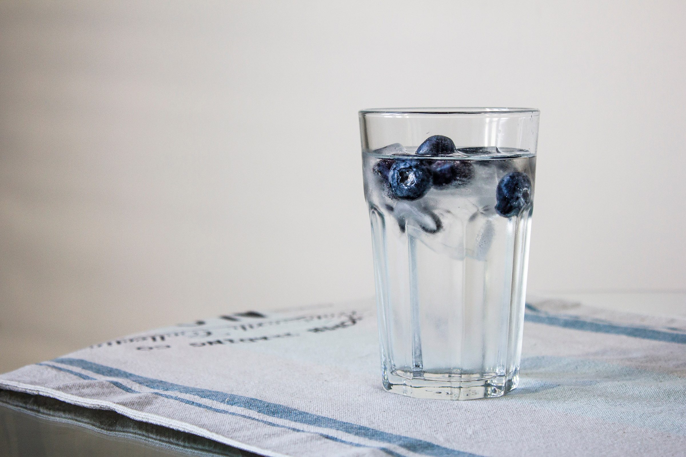 glass of fresh water with blueberry ice cubes