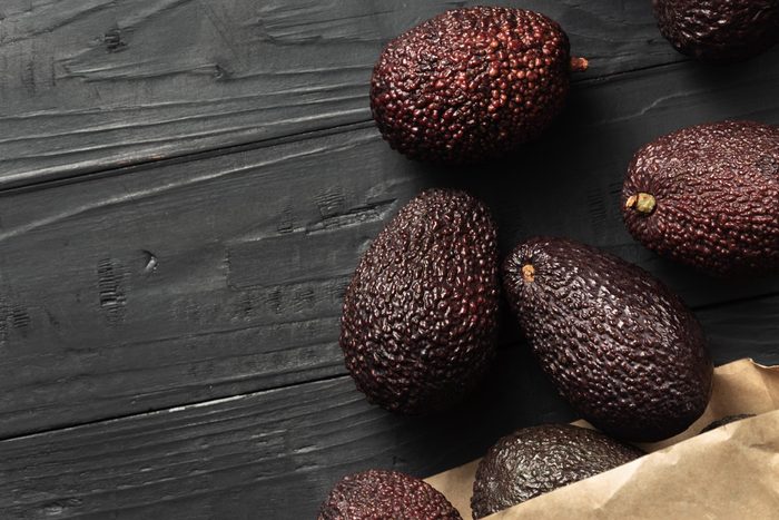 avocados on table and brown bag