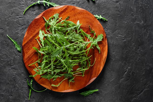 arugula on wooden plate