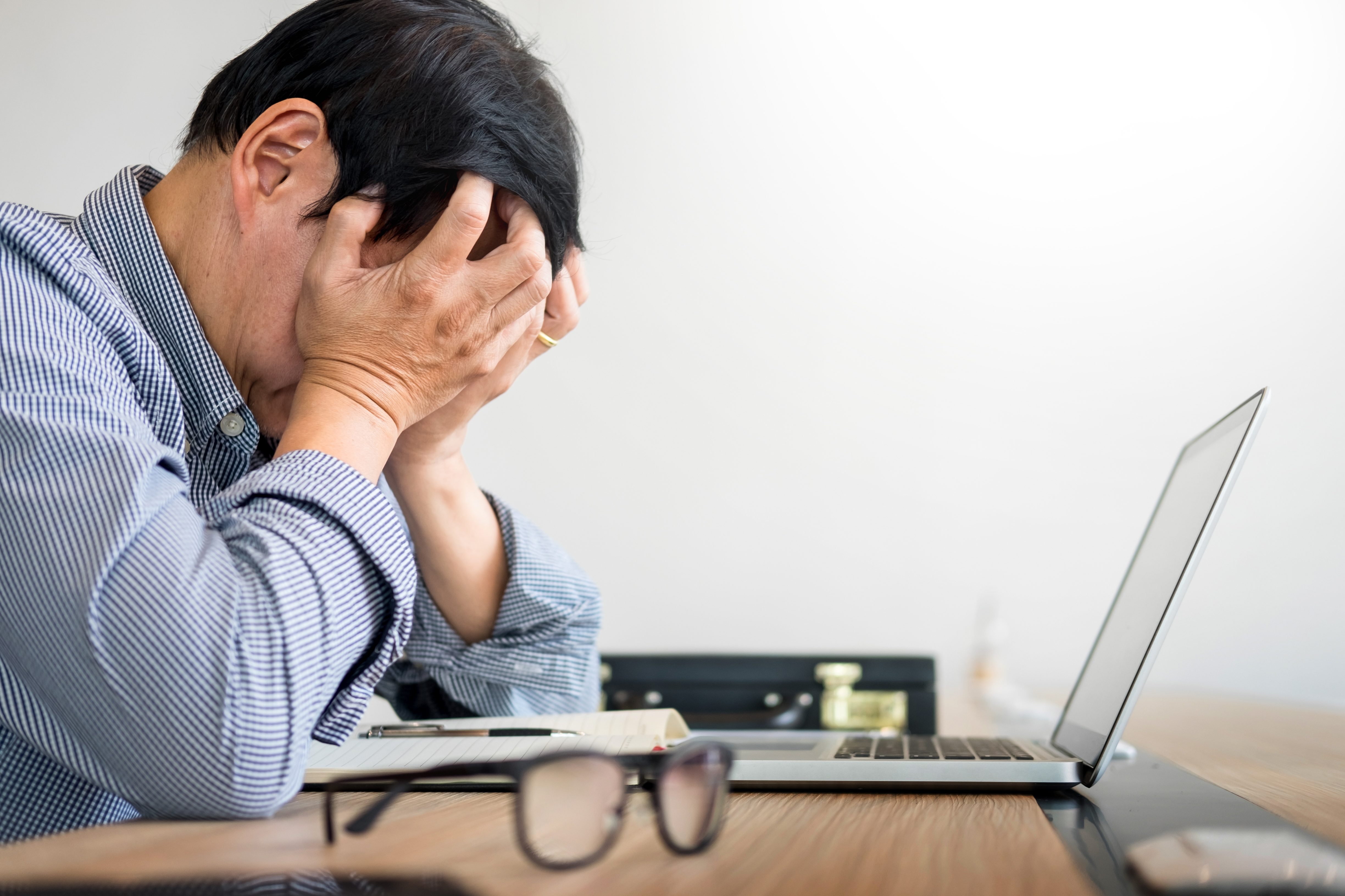 Stressed businessman Feeling sick and tired while sitting at his working place in office, deadline concept