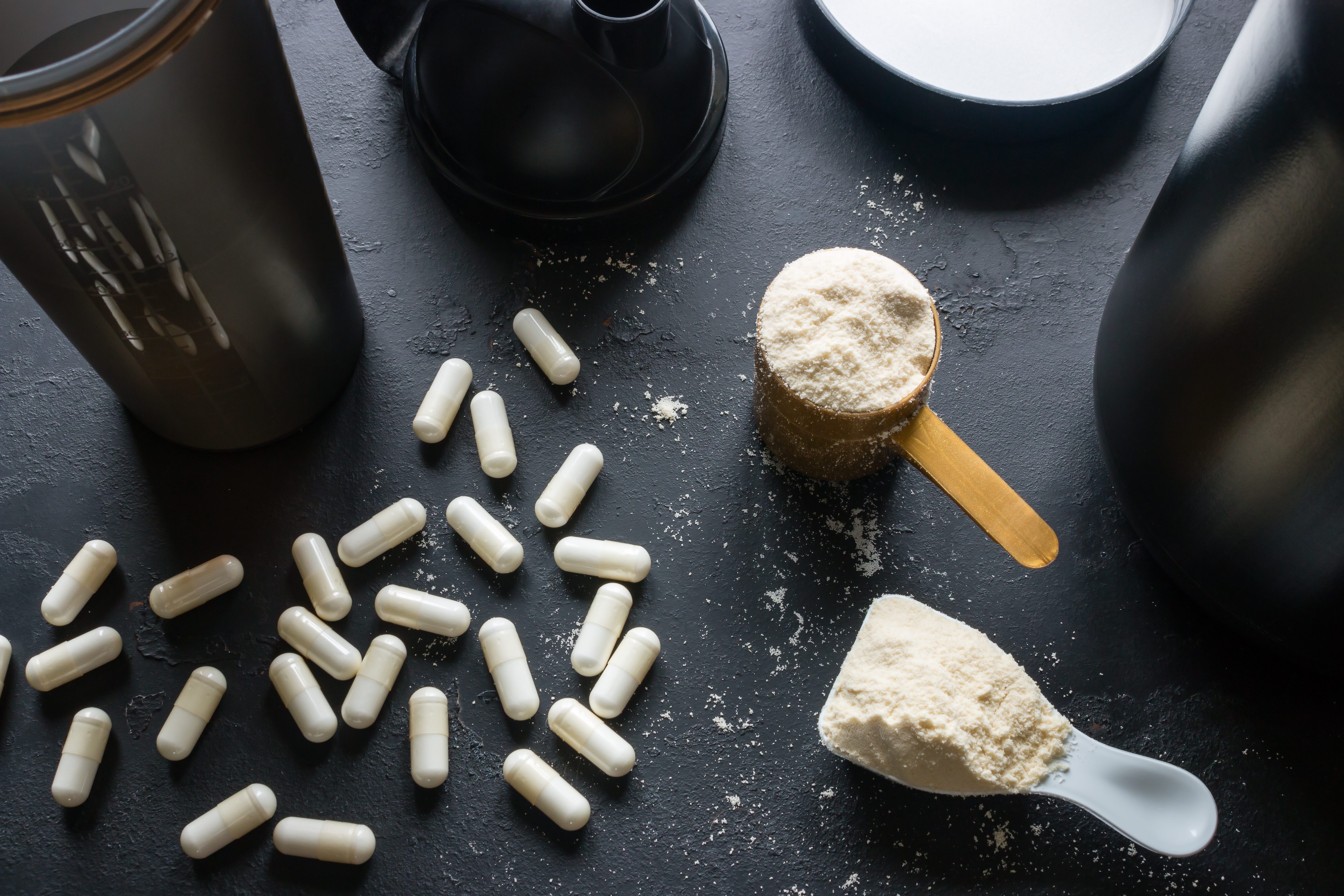 shaker and various sports supplements on a black background