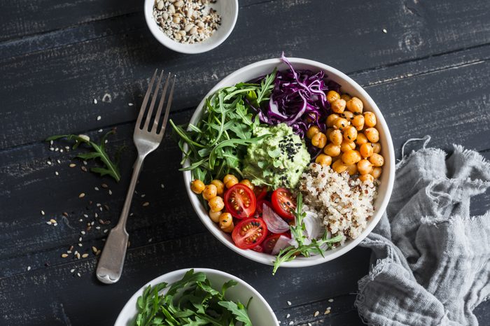 Quinoa and spicy chickpea vegetable vegetarian buddha bowl. Healthy food concept. On a dark background, top view 