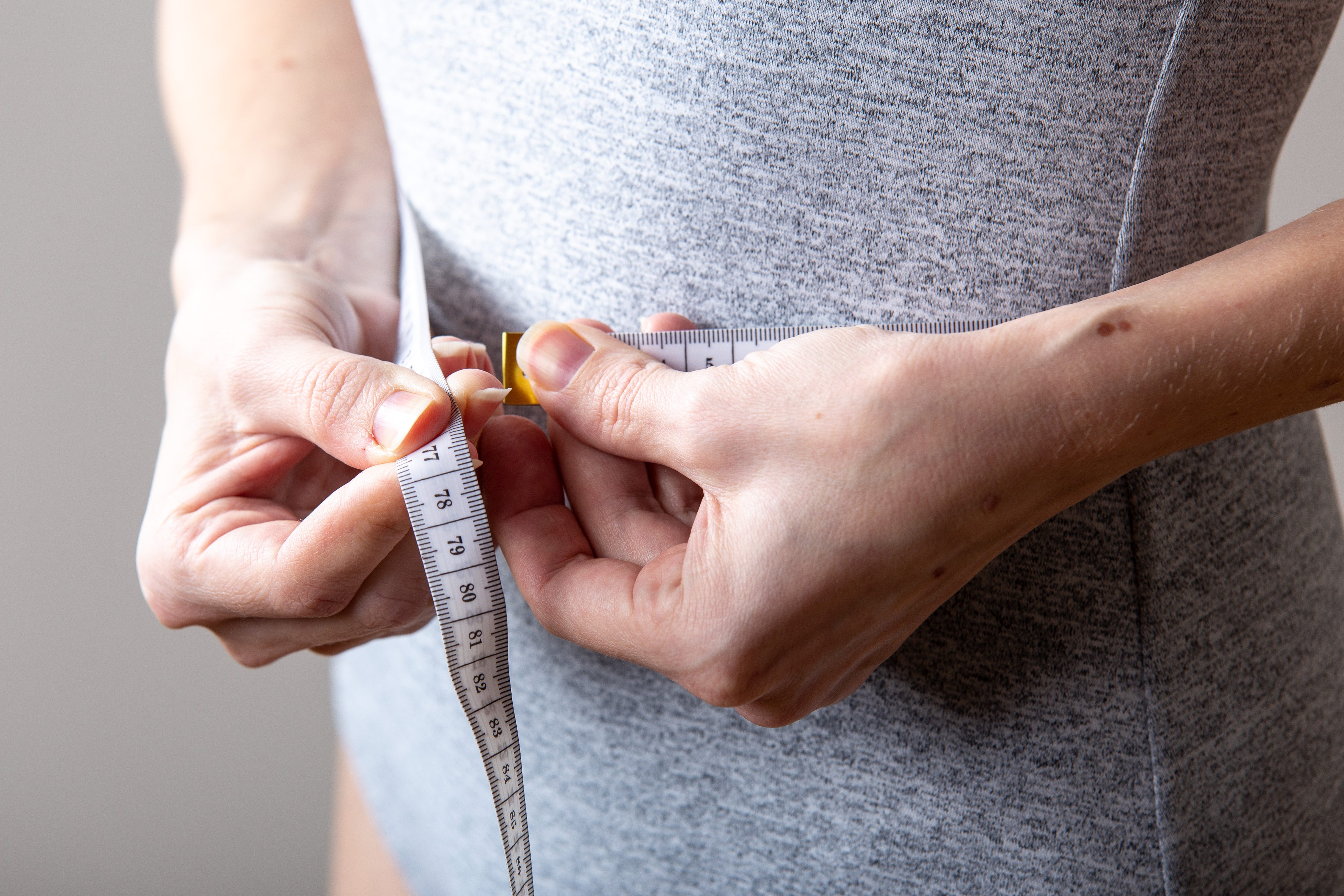 woman measuring waist. sport and healty concept