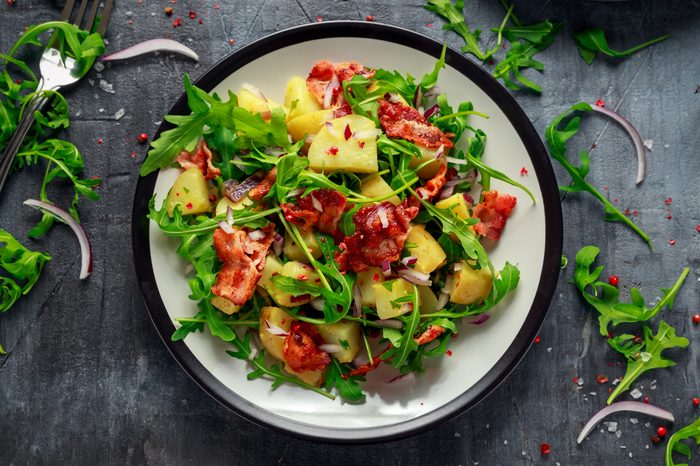 Fresh crispy Bacon, Potato salad with green vegetable on plate