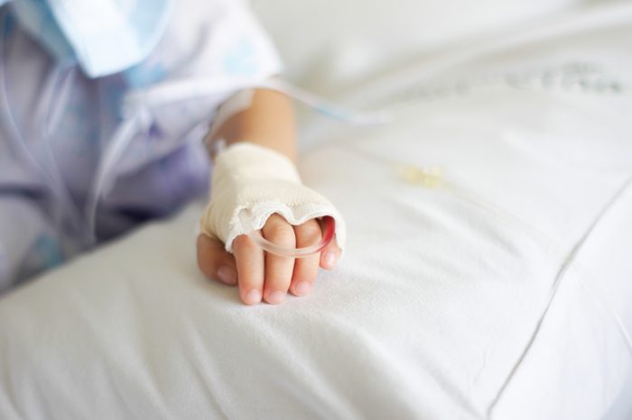 Saline intravenous (iv) drip in a Children's patient hand