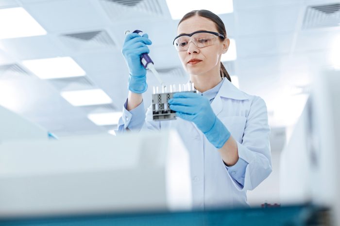 Serious female technician doing analysis