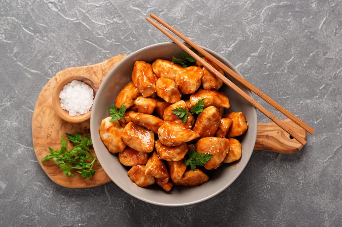 bowl of orange chicken with chopsticks