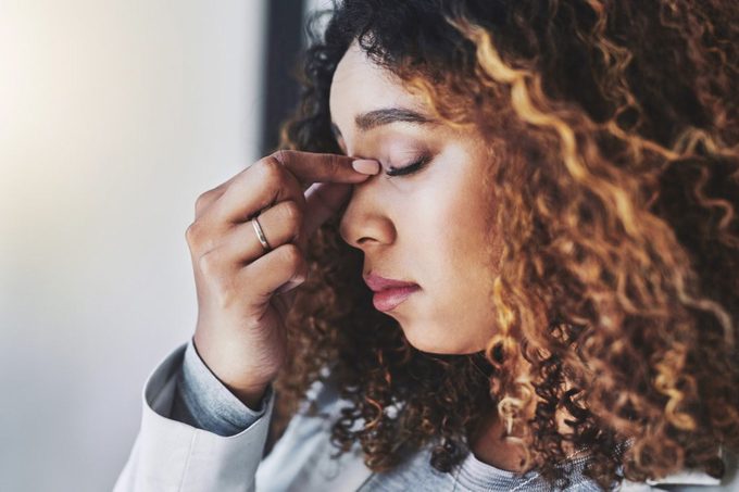 Woman with eyes closed pinching the bridge of her nose