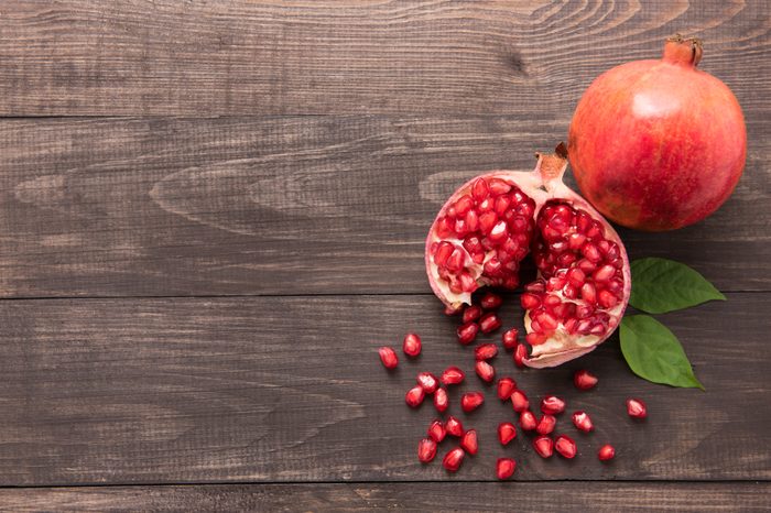 Ripe pomegranate fruit on wooden vintage background.