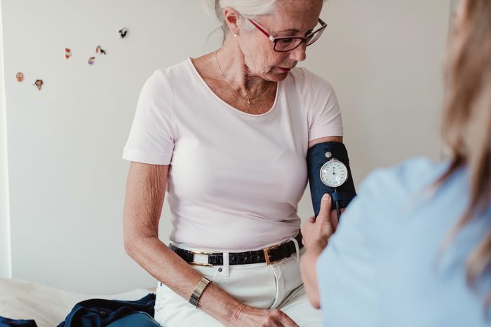 woman having blood pressure checked in doctor's office