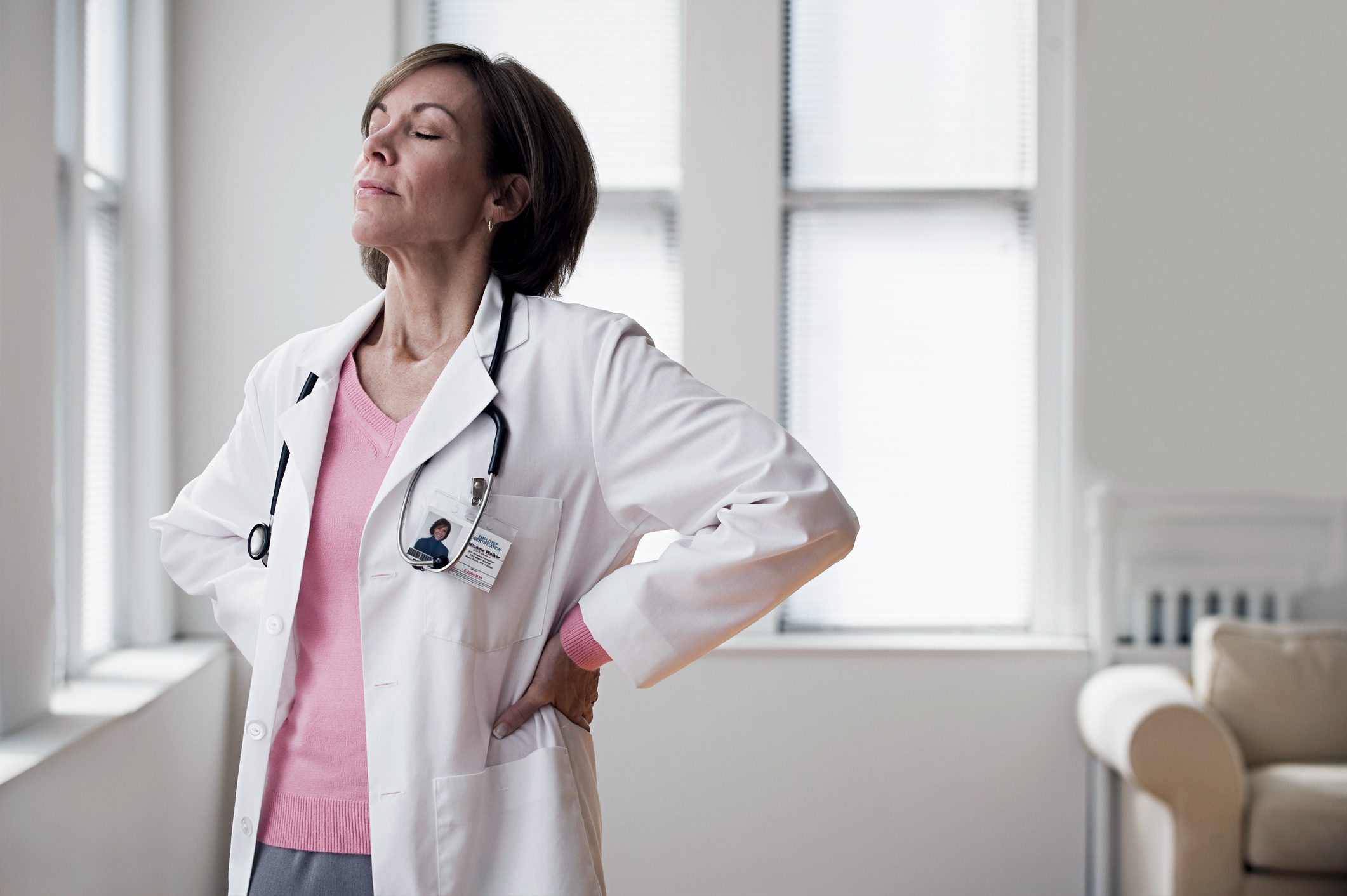 female doctor taking a deep breath in office