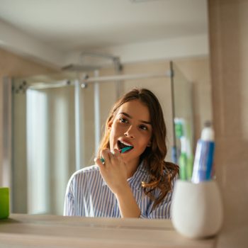 young woman brushing her teeth