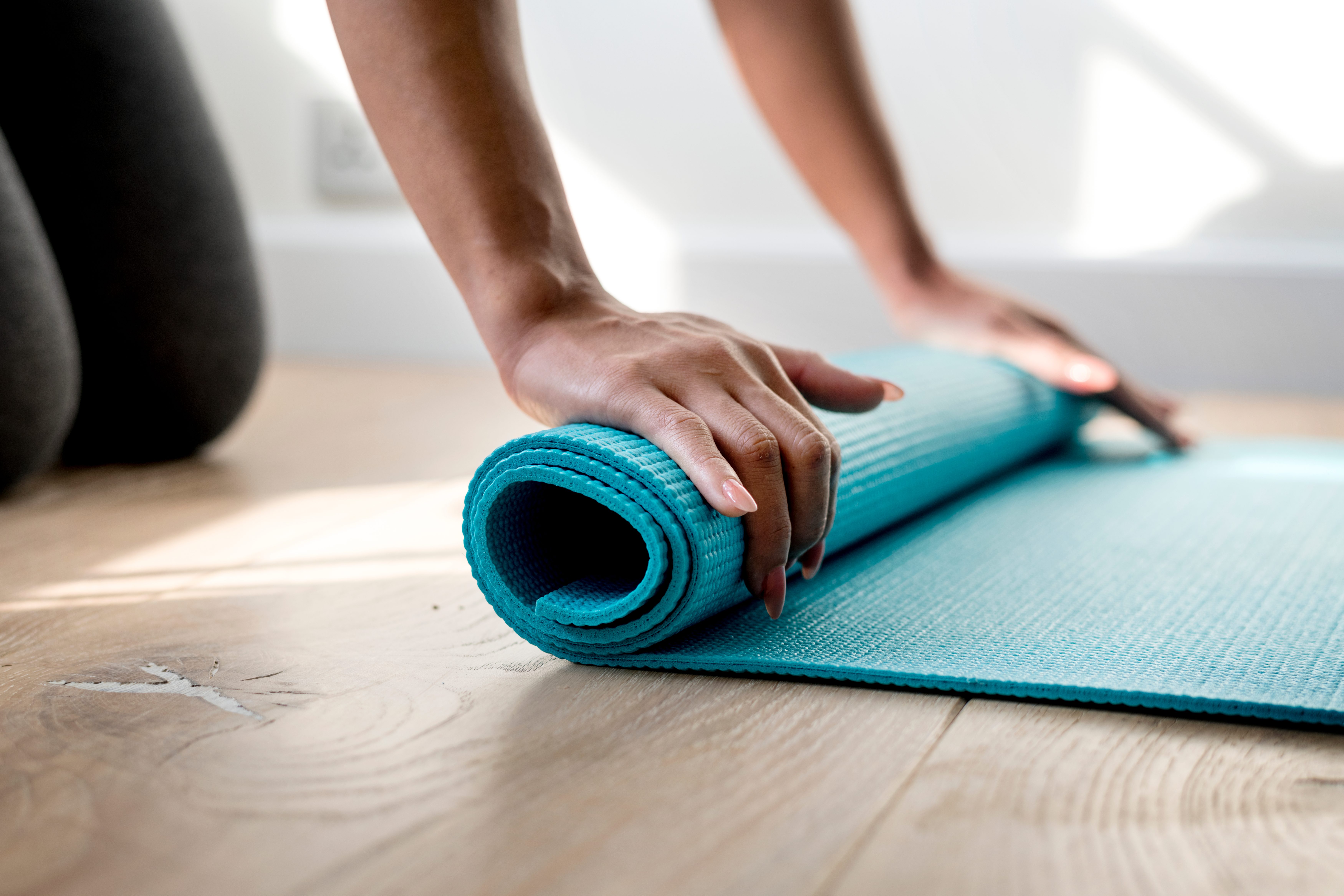 woman rolling up yoga mat