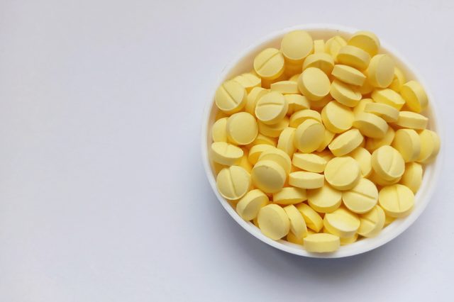 Yellow pills in white cap on white background. ; Shutterstock ID 1532737580; Job (TFH, TOH, RD, BNB, CWM, CM): RD