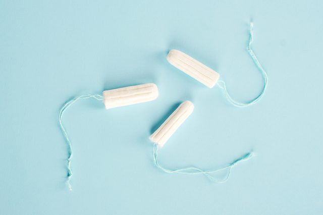 Hygienic tampons on a blue background. Three tampons of varying absorbency: normal, super, super plus. View from above.