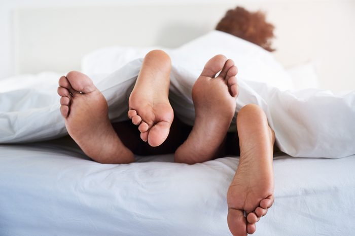 couple in bed together feet