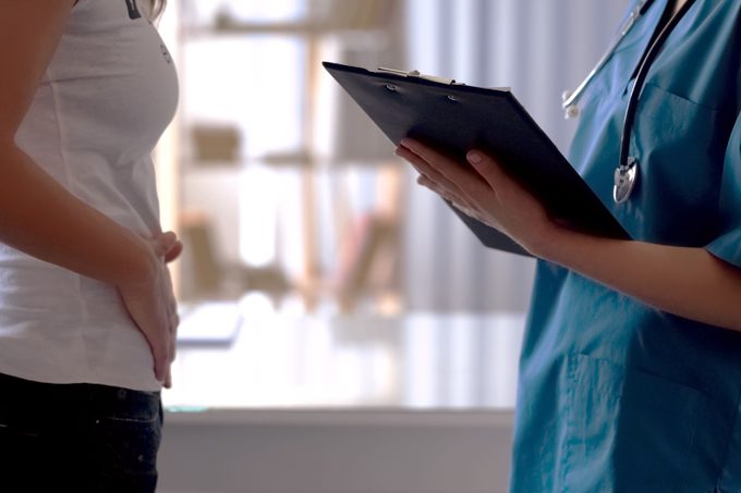 woman talking with doctor about stomach pain, irritable bowel syndrome, colon cancer