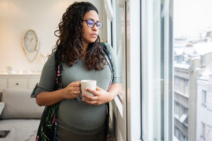 woman at home sad looking out window