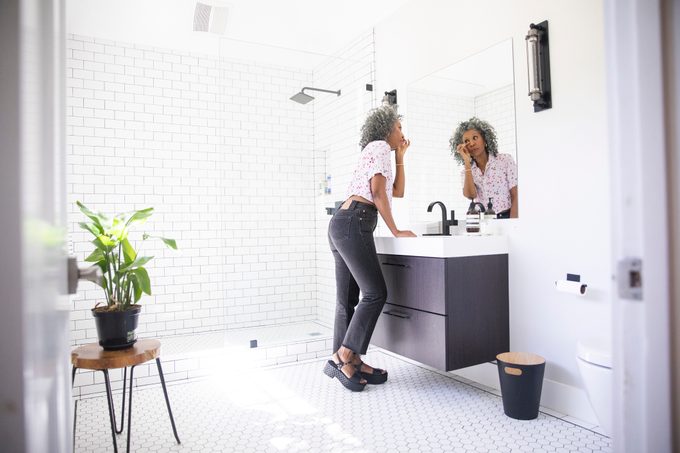 middle aged woman in the bathroom getting ready for the day