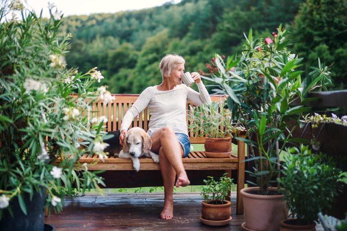 woman sitting outside drinking a cup of coffee