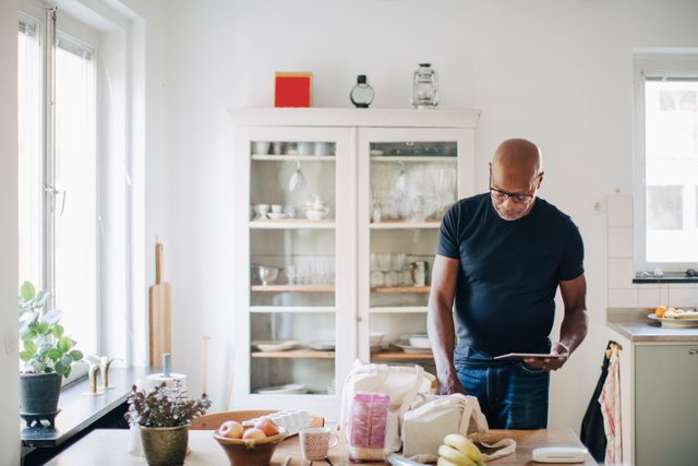 man sorting through groceries in kitchen