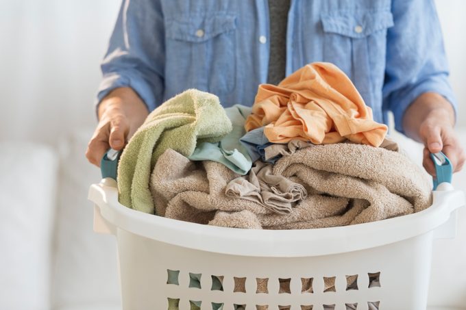 close up of man holding laundry hamper