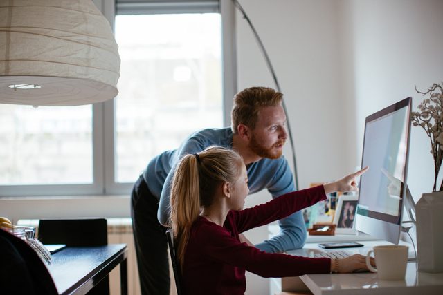father helping daughter with school work