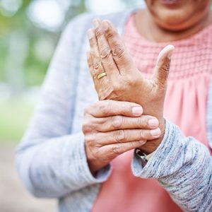 close up of woman suffering from arthritis in her hand