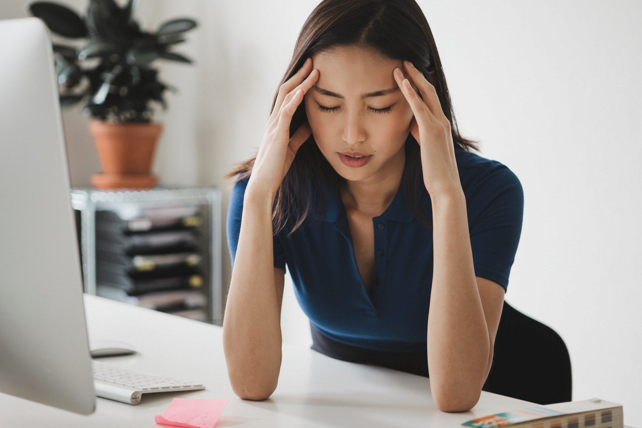 woman suffering from headache while working from home