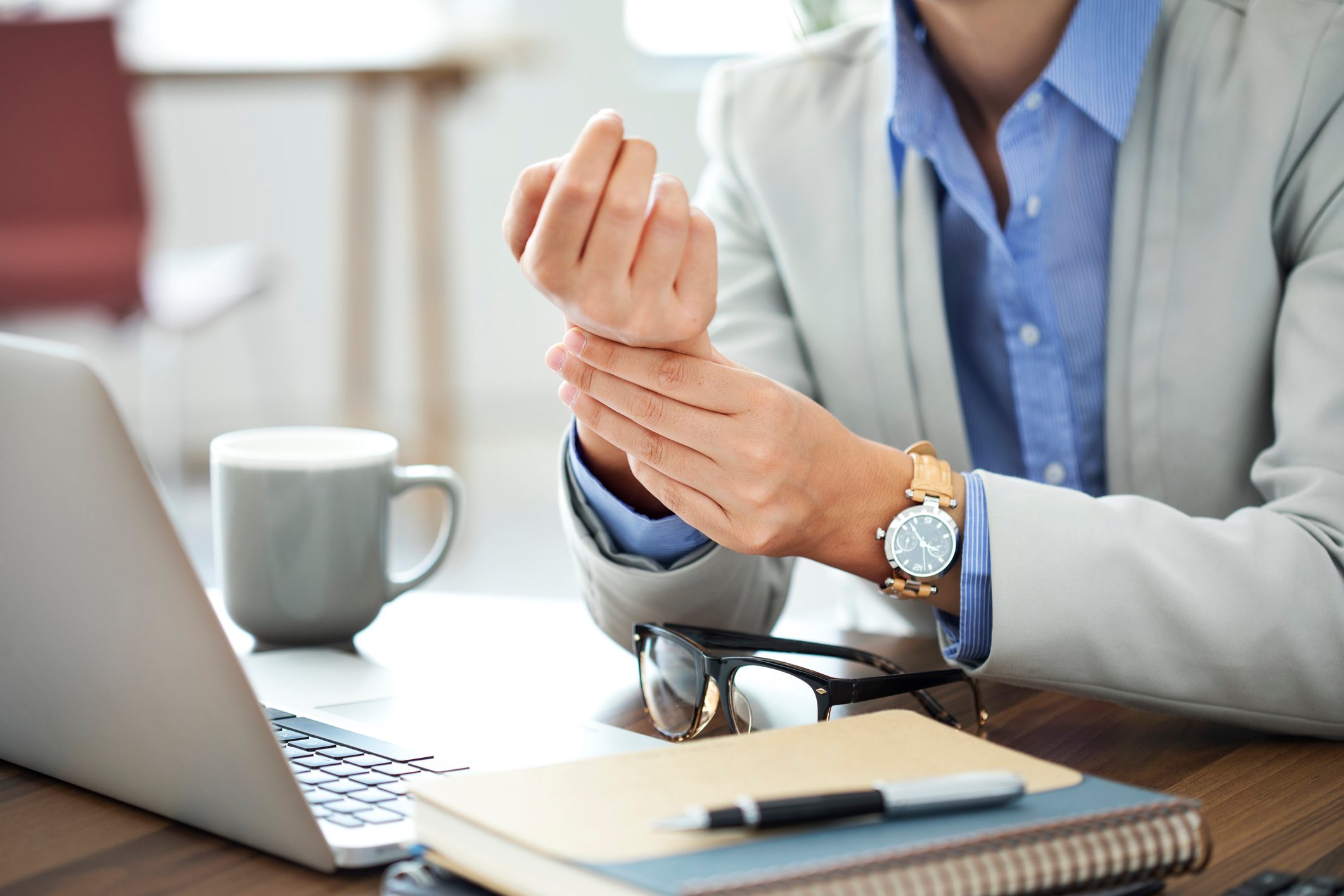 woman holding her painful wrist and hand