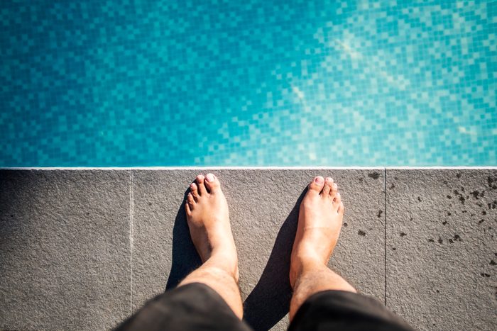 Man standing by Swimming Pool