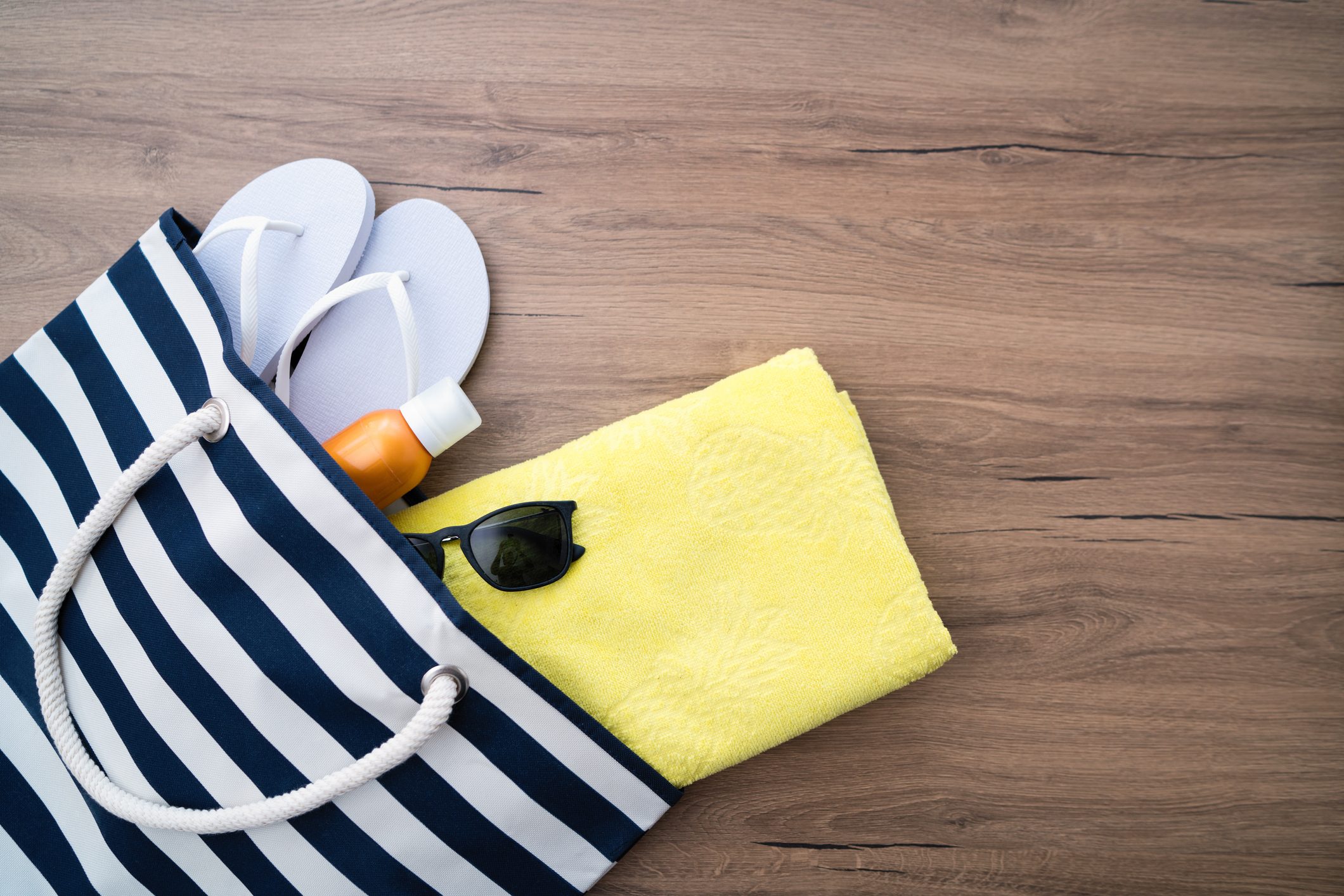beach bag with flip flops towel and sunglasses overhead