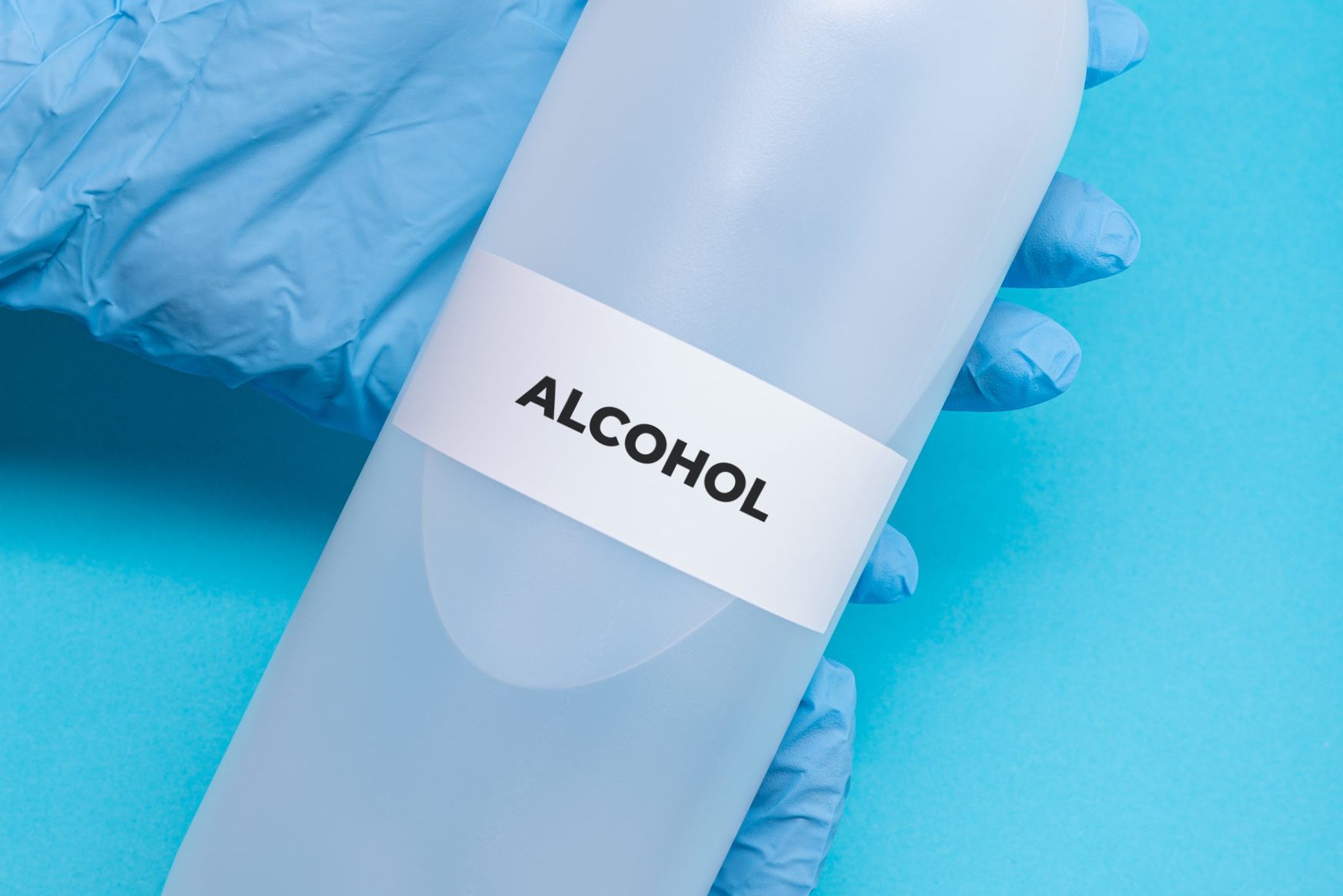 rubbing alcohol bottle on blue background