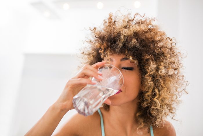 woman drinking water from glass