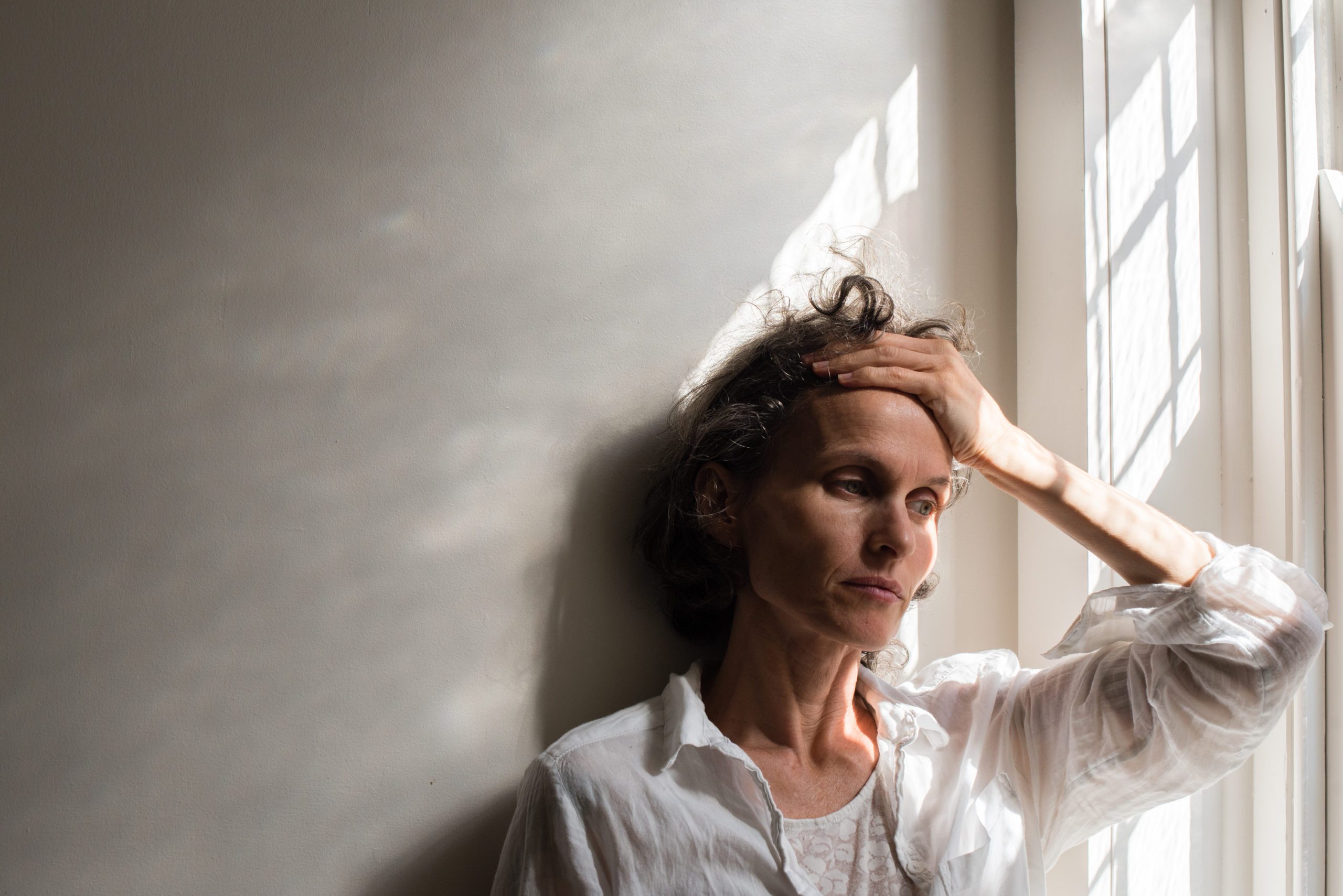 stressed woman at home with hand on forehead