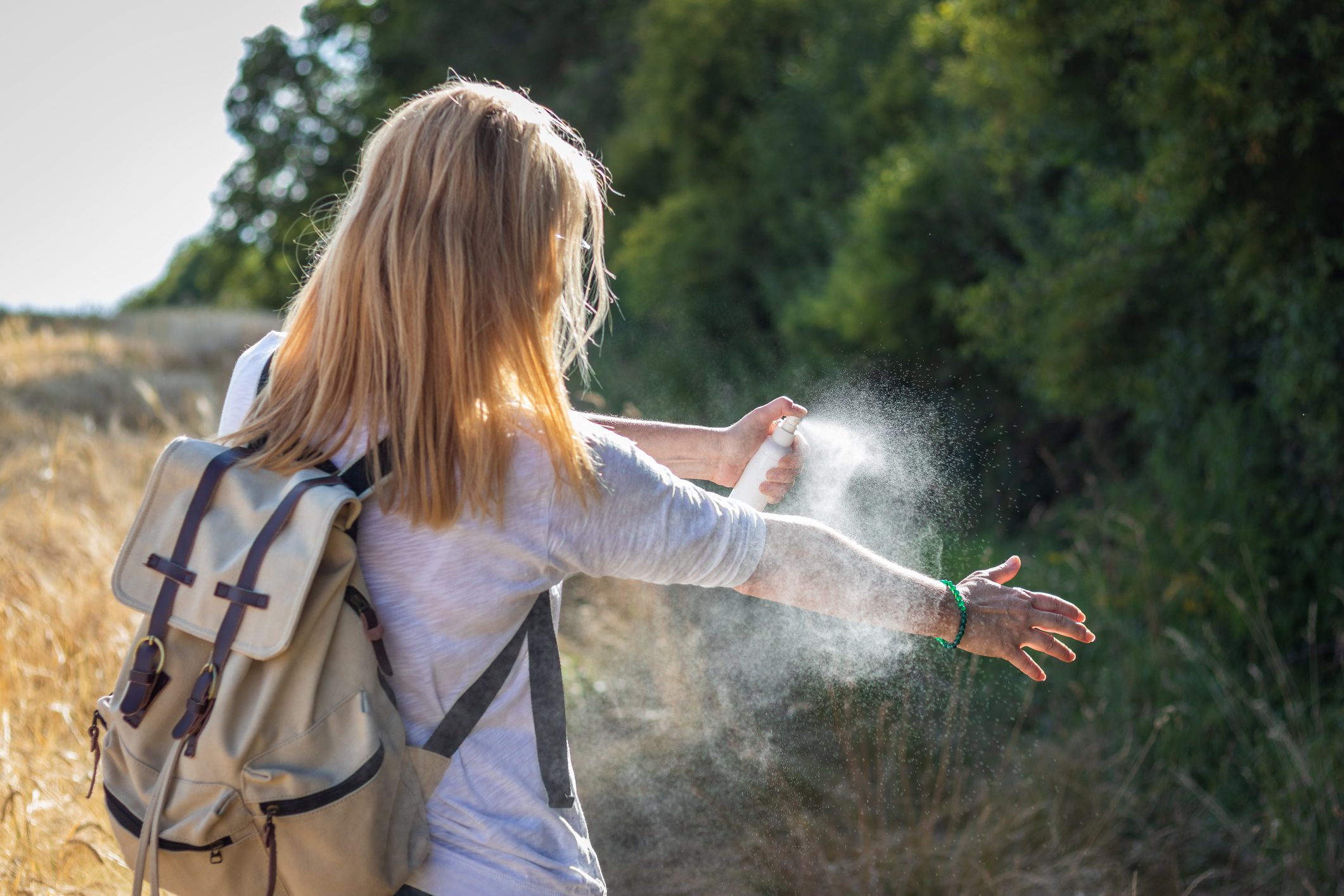 woman applying bug spray to arm