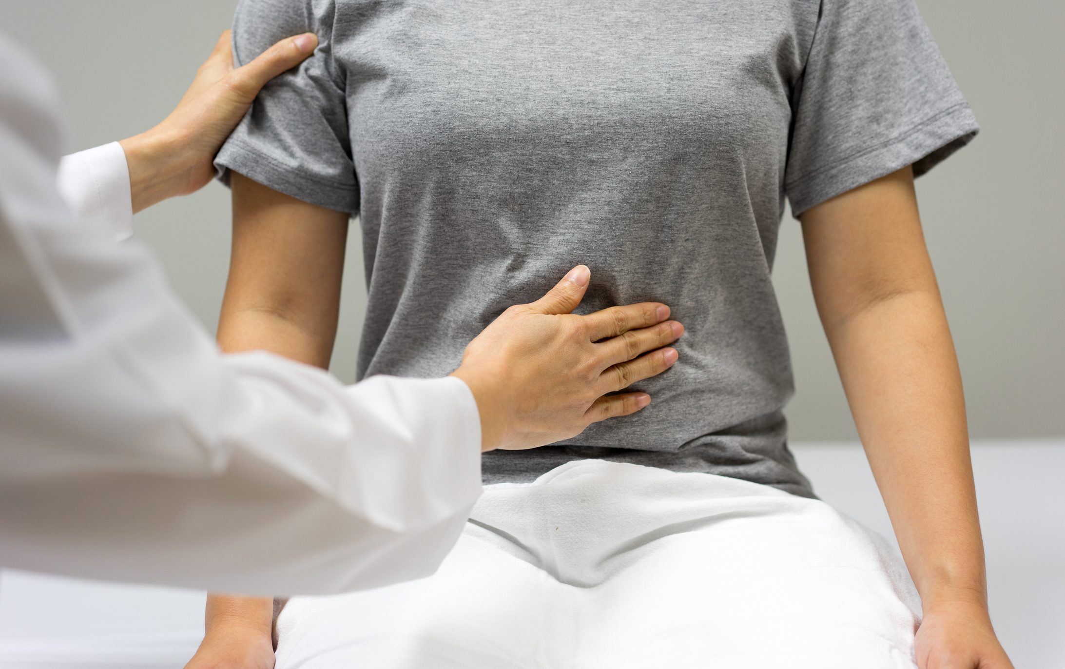 cropped close up of doctor examining patient's stomach