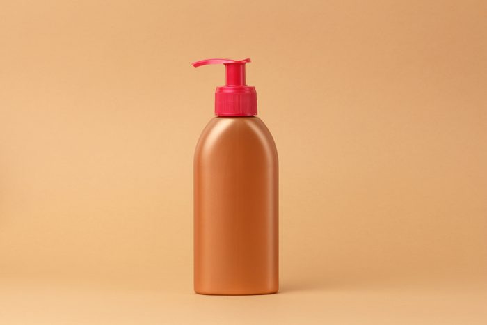 bronzing lotion bottle on beige background