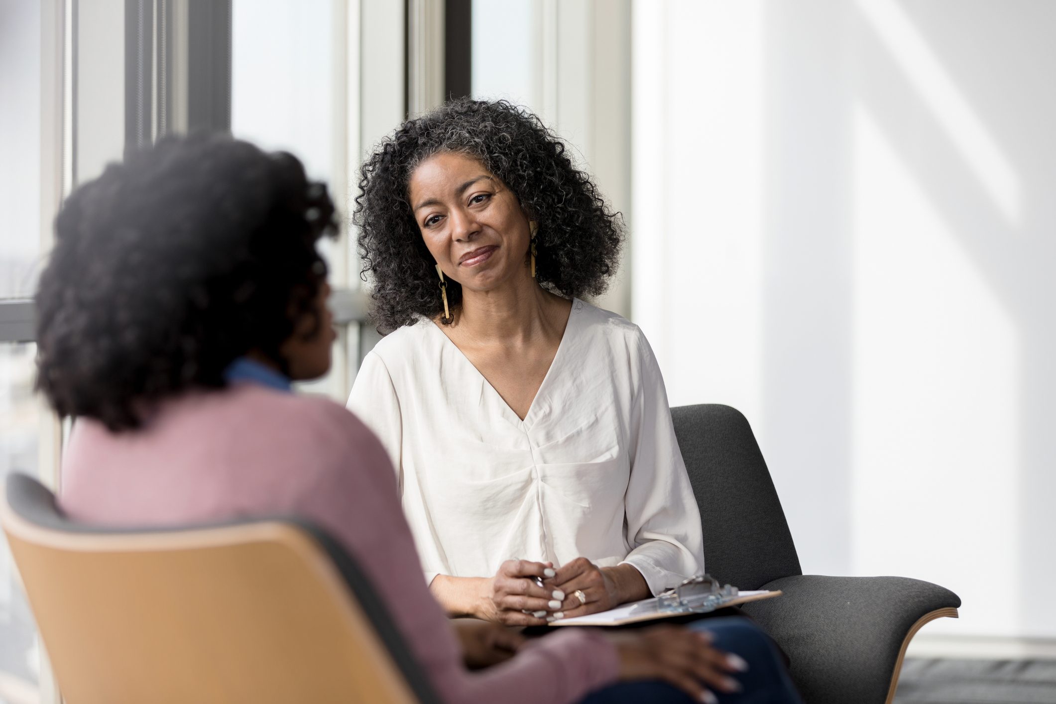 mature psychologist or therapist talking with patient