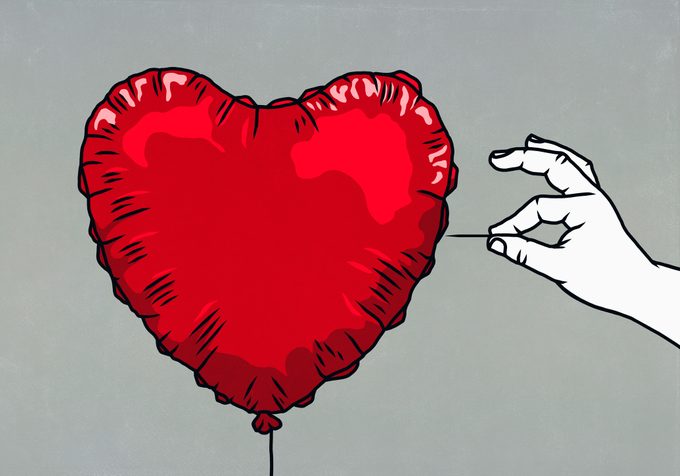 hand with pin ready to pop red heart balloon illustration