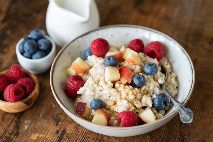 Oatmeal porridge with berries and honey on wooden table