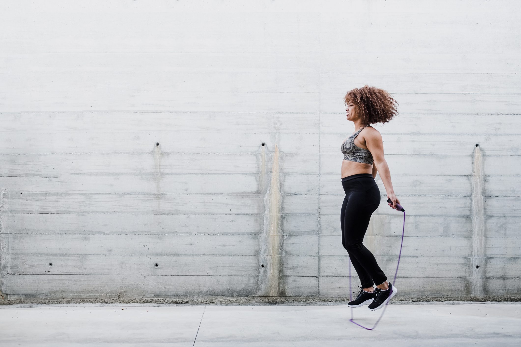 Woman Skipping Rope In Urban Area