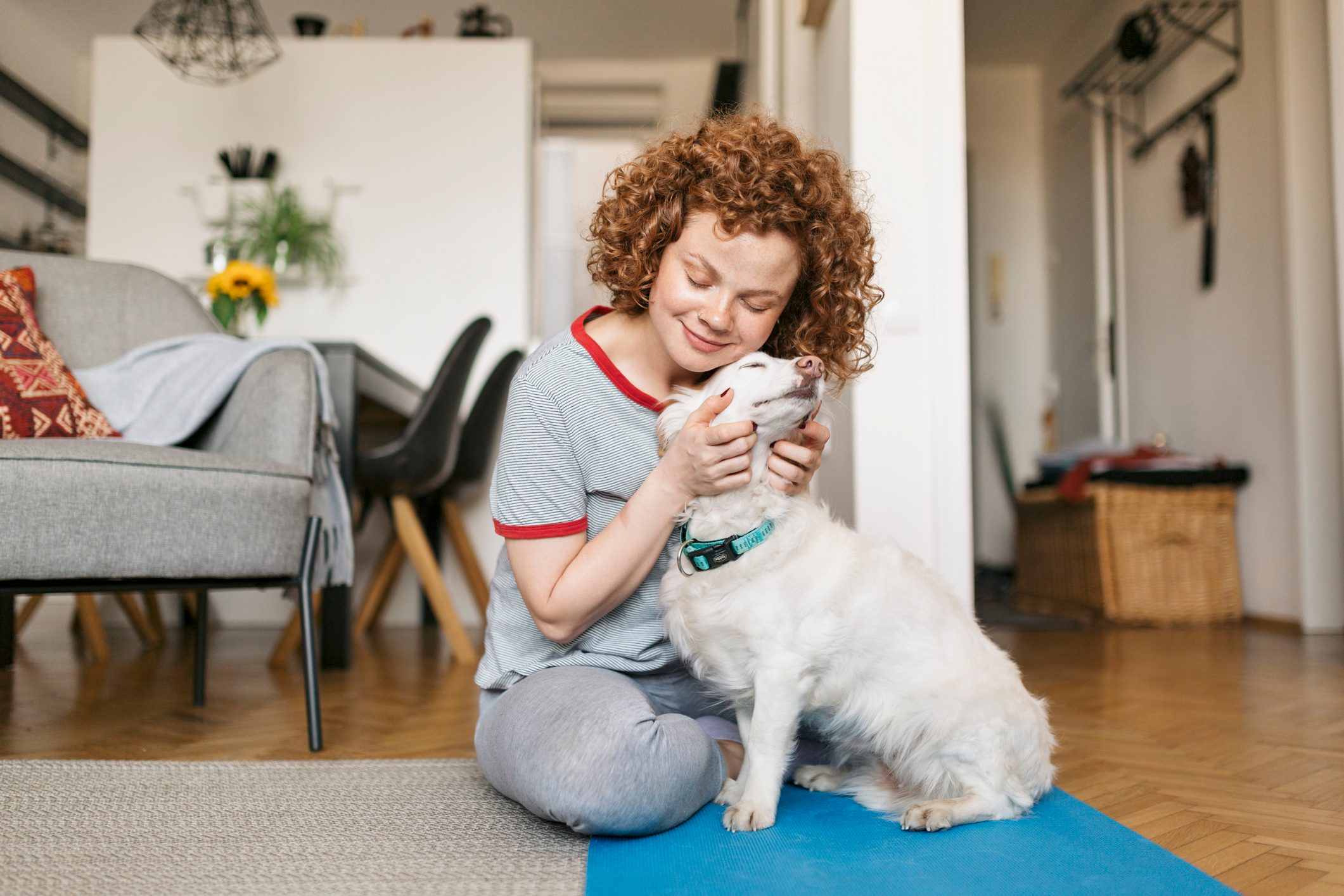 happy young woman hugging her dog at home