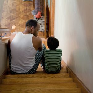 father and son having a conversation sitting on the stairs at home