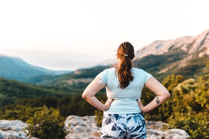 Woman with diabetes wearing a CGM and making a ponytail